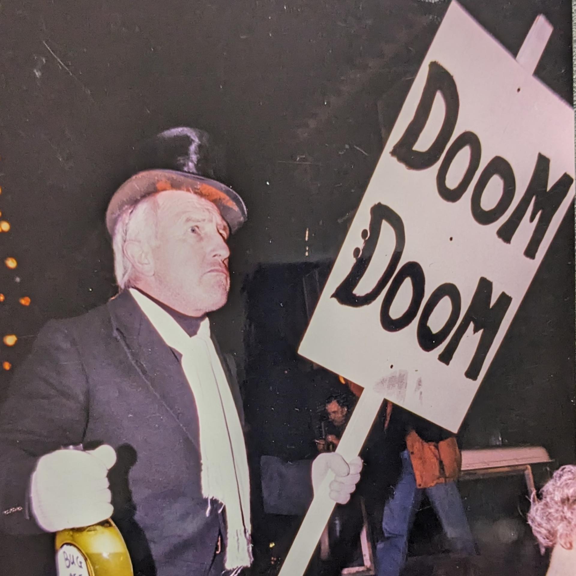 old man with a placard saying 'doom doom'.